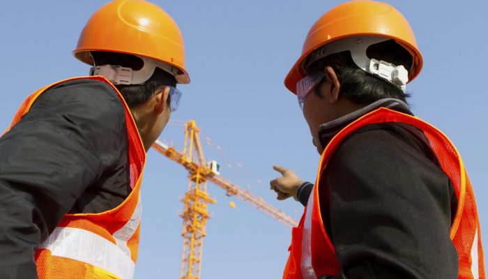 Site manager with safety vest discussion under construction